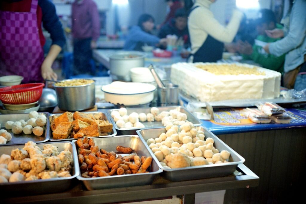 A bustling night market scene in New Taipei City featuring diverse street foods and lively atmosphere.